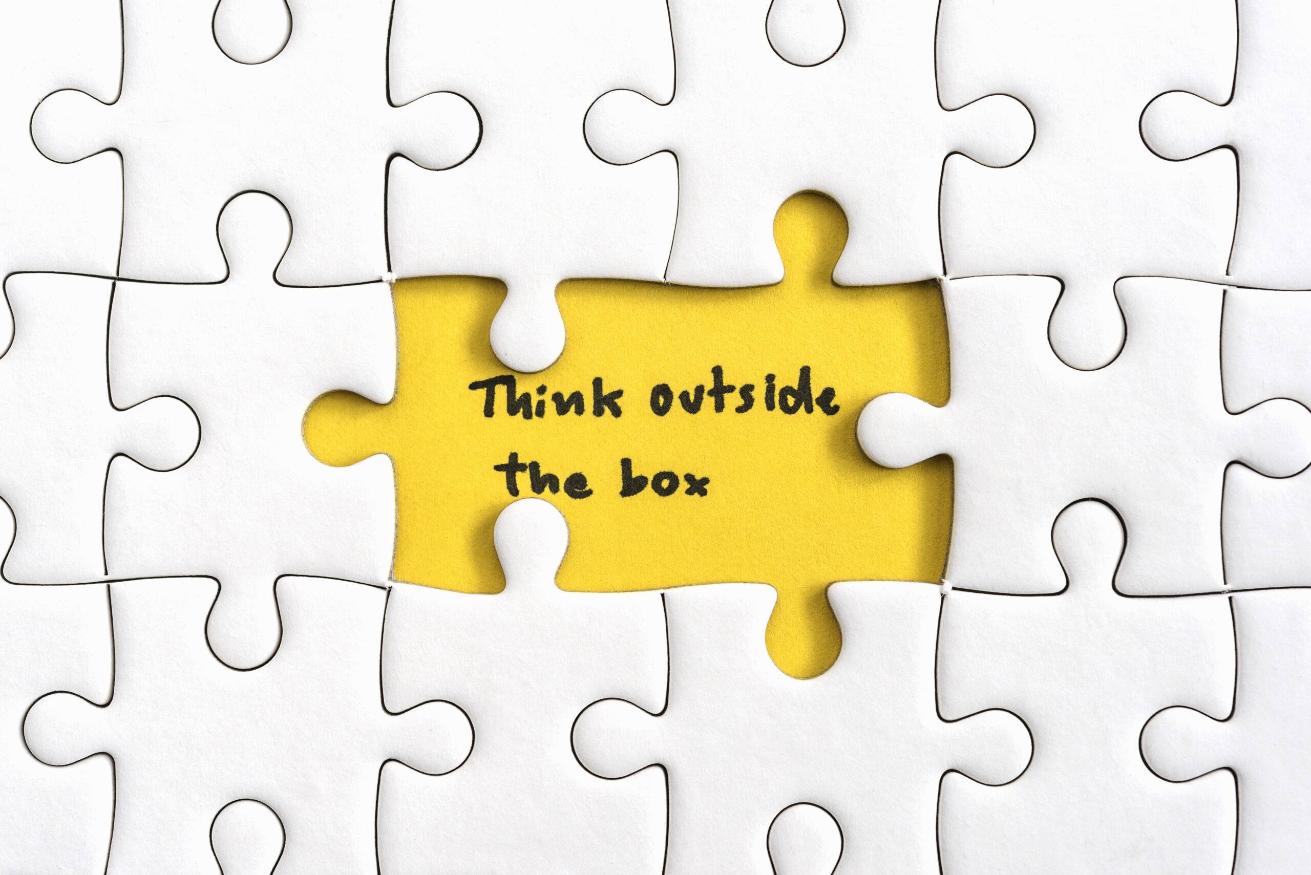 Jigsaw puzzle piece with two missing and hand writing letters word think outside the box, Quotes business concept